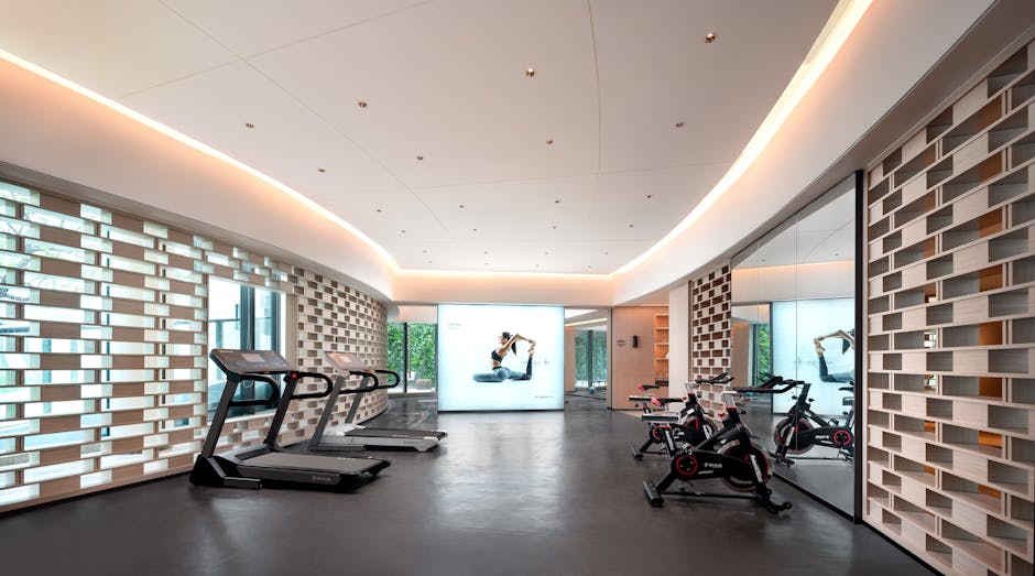 Sleek gym interior with treadmills and stationary bikes, technology-focused design.